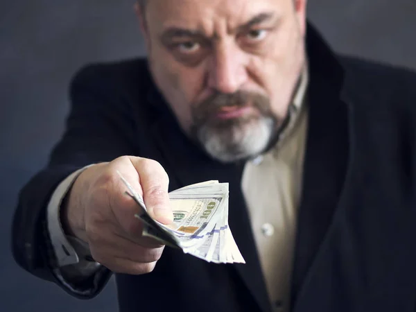 Bearded man in a black suit gives money. Corruption. Illegal operations — Stock Photo, Image