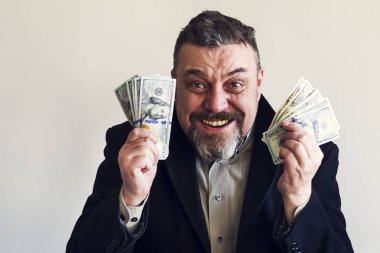 Onun elinde dolarla mutlu sakallı adam. Başarı. Finans.