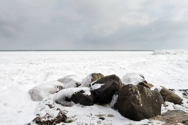 Pedras na neve na margem do mar gelado. Dinamarca. Mar Báltico. Fenómenos naturais. Capa do mar . — Fotografia de Stock