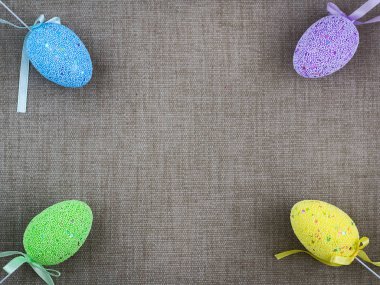 Arka plan gri kumaş üzerinde çok renkli Paskalya yumurtaları. Kopya alanı.
