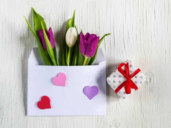 Beautiful tulips in mail envelope. Copy space. White wooden background. Mother's Day, Happy Women's Day — Stock Photo, Image