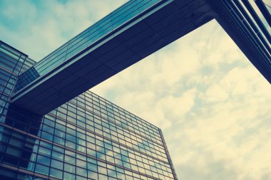 Güzel, modern, yansıtılmış bir bina. Aşağıdan manzara. Gökyüzü bulutlu. Kurumsal yapı.