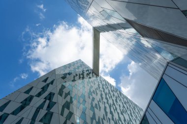 Kopenhag. Danimarka. 24 Temmuz. 2019: Bir cam binanın cephesi. Bulutlu gökyüzü Alt görünümü. Close. Mimari.
