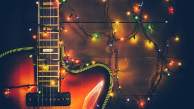 Parlak bir çelengi olan eski bir caz elektro gitarı. Müzisyen ve gitarist için yeni yıl tebrik kartı..