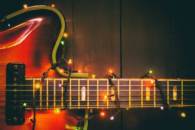 Parlak bir çelengi olan eski bir caz elektro gitarı. Müzisyen ve gitarist için yeni yıl tebrik kartı..