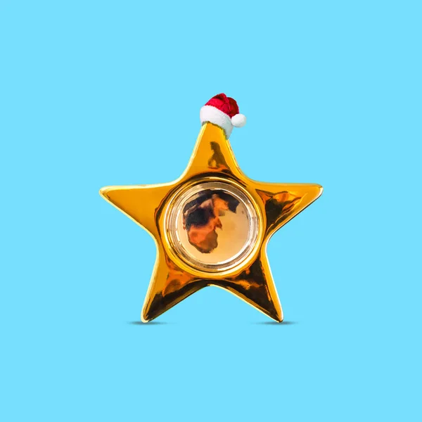 Złota gwiazda w kapeluszu Mikołaja na niebieskim tle. Odizolowany. Tło świąteczne. — Zdjęcie stockowe