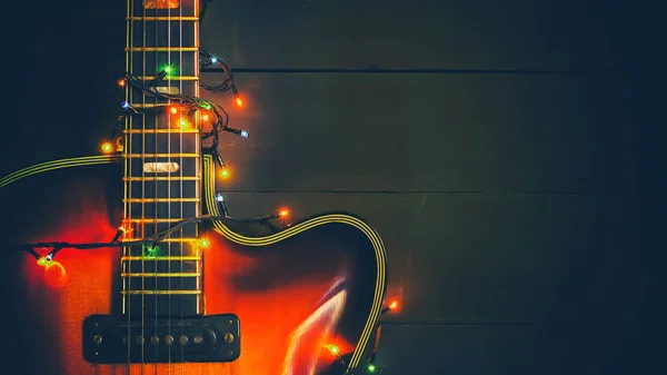 Stara, jazzowa gitara elektryczna ze świetlaną girlandą. Noworoczna kartka z życzeniami dla muzyka, gitarzysty. — Zdjęcie stockowe