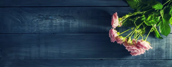 Hermosas rosas sobre una mesa de madera oscura. Día de San Valentín, fondo del Día de la Madre. Copiar espacio . — Foto de Stock