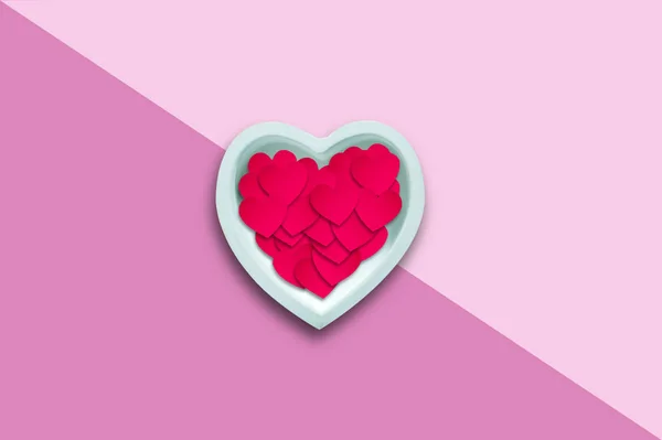 Paper hearts in a ceramic heart on a pink background .. Happy Valentines Day background. — ストック写真