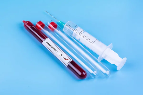 Coronavirus Muestra de sangre en el tubo de ensayo y una jeringa para su análisis. La medicina. Analiza. Virus . — Foto de Stock