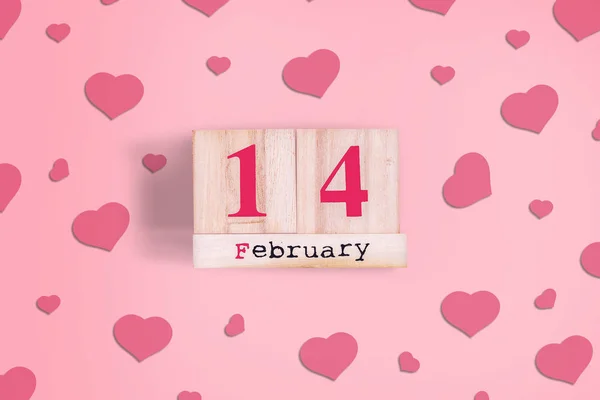 14 de febrero. Calendario de madera sobre fondo rosa con corazones. Fondo día de San Valentín . —  Fotos de Stock