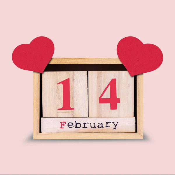Op 14 februari. Houten kalender met rode hartjes op een roze achtergrond. Valentijnsdag achtergrond. — Stockfoto