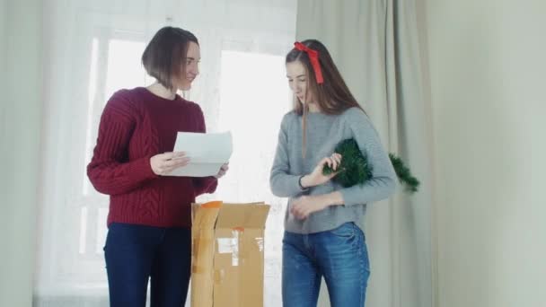 Two young girl preparing Christmas tree for decorations and having fun New year — Αρχείο Βίντεο