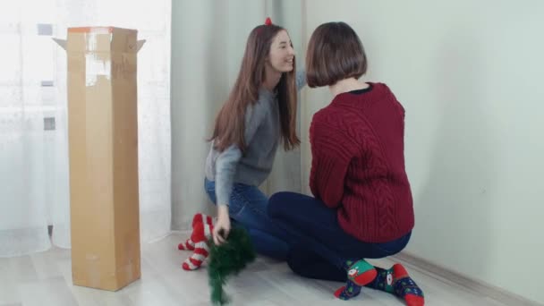 Dos jóvenes preparando el árbol de Navidad para las decoraciones tomando selfie divertirse — Vídeo de stock