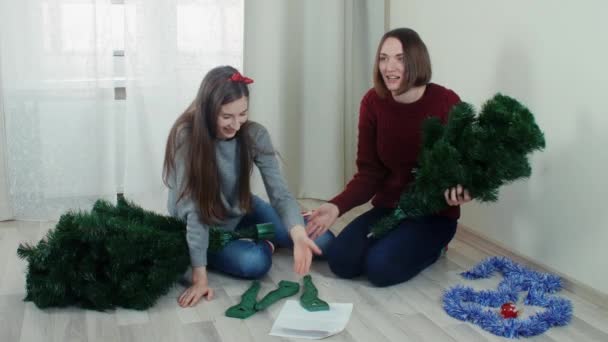 Two quarreling girls preparing Christmas tree for decorations — ストック動画