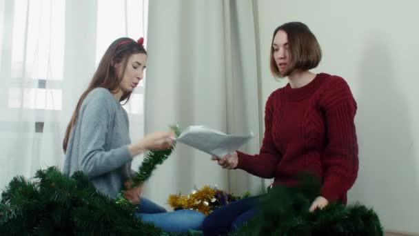 Two young girl preparing Christmas tree for decorations and having fun New year — Stock Video