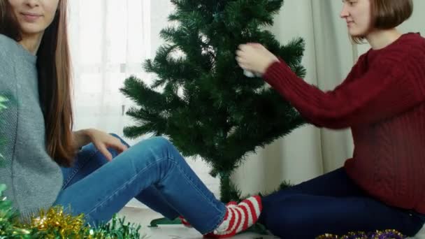 Two young women decorating Christmas tree New year preparation having fun — Stock video