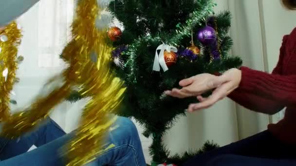 两个年轻妇女装饰圣诞节树开心的新的一年准备 — 图库视频影像