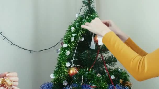 Zwei junge Frauen schmücken Weihnachtsbaum Neujahrsvorbereitung mit Spaß — Stockvideo