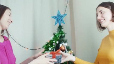 Yakınındaki bir Noel ağacı Noel hediyeler vererek mutlu kızlar
