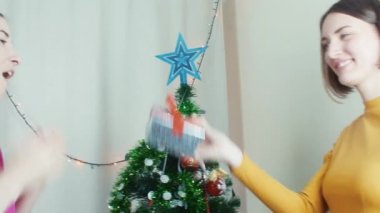 Yakınındaki bir Noel ağacı Noel hediyeler vererek mutlu kızlar