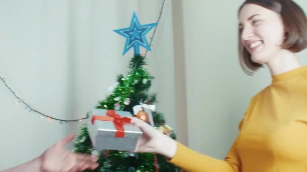 Chicas felices dando regalos de Navidad cerca de un árbol de Navidad — Vídeos de Stock