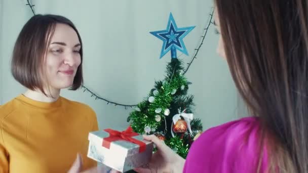 Dos chicas alegres dando regalos de Navidad abriéndolos con decepción — Vídeos de Stock