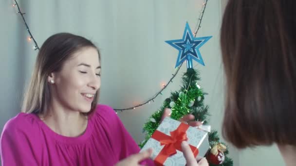 Dos chicas alegres dando regalos de Navidad abriéndolos con decepción — Vídeos de Stock