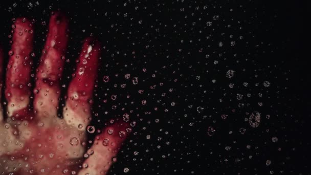 창 유리 깊은 어두운 배경에서 피 묻은 손 — 비디오