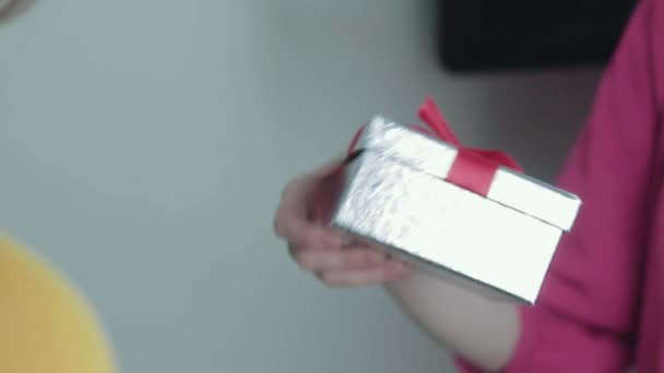 Χέρια του κοριτσιού δίνοντας δώρο σε φίλο κοντά χριστουγεννιάτικο δέντρο κοντά — Αρχείο Βίντεο