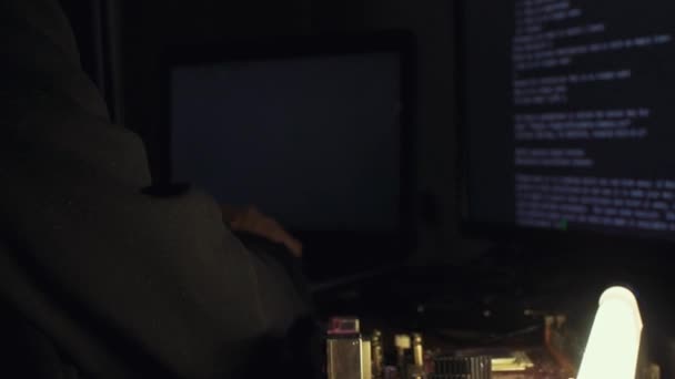 Hacker em código de rachaduras capuz usando computadores na sala escura — Vídeo de Stock