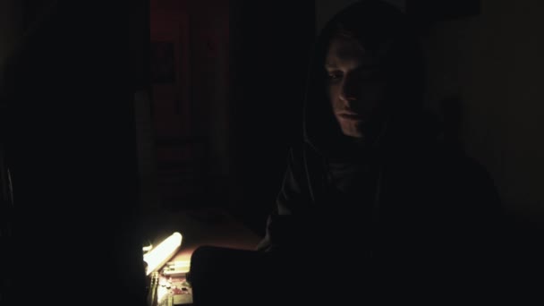 Hacker in hood cracking code using computers in dark room — Stock Video