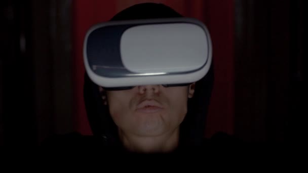 Programador criminal no capuz usando óculos VR no quarto escuro de perto — Vídeo de Stock