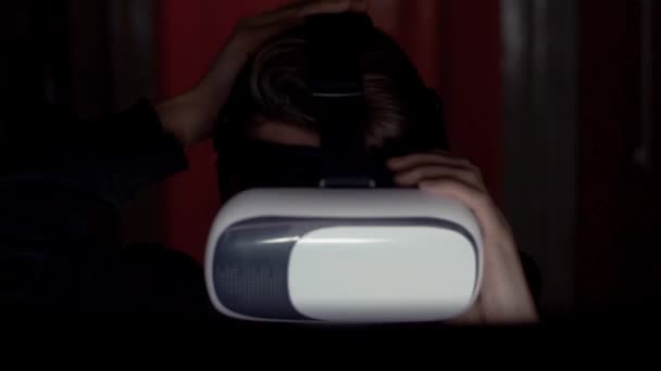 Programador criminal no capuz usando óculos VR no quarto escuro de perto — Vídeo de Stock