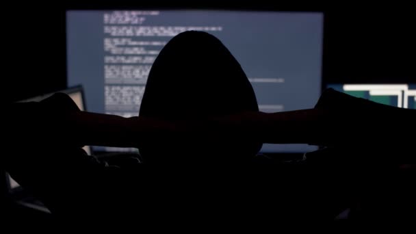 Hacker en código de craqueo de capucha usando computadoras en cuarto oscuro — Vídeo de stock