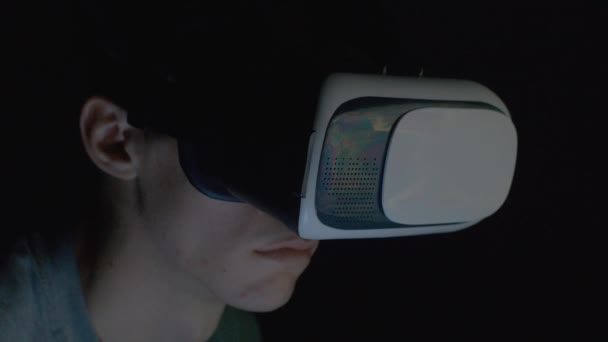 Young man using VR glasses in dark room close up — Stock Video