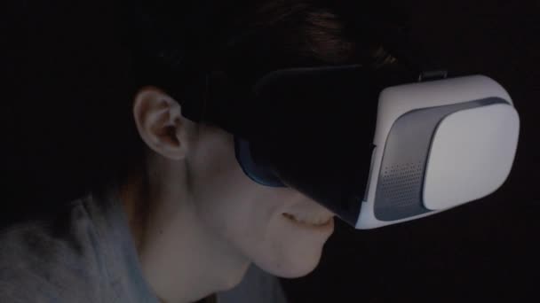 Young man using VR glasses in dark room close up — Stock Video