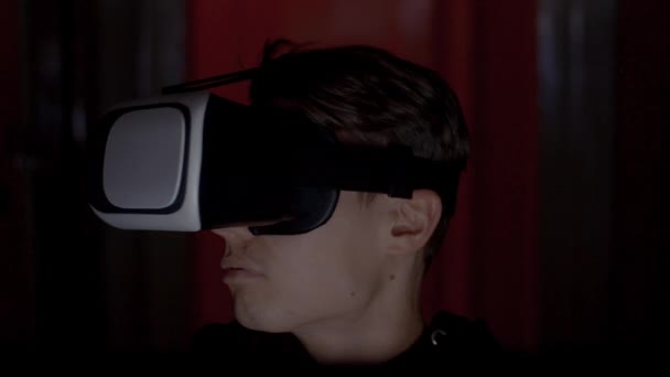 Criminal programmer in hood using VR glasses in dark room close up — Stock Video