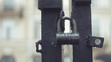 Asma kilit üzerinde yağmur altında demir kapıları kapatın