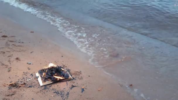 Libro ardiente en la arena en la costa — Vídeos de Stock