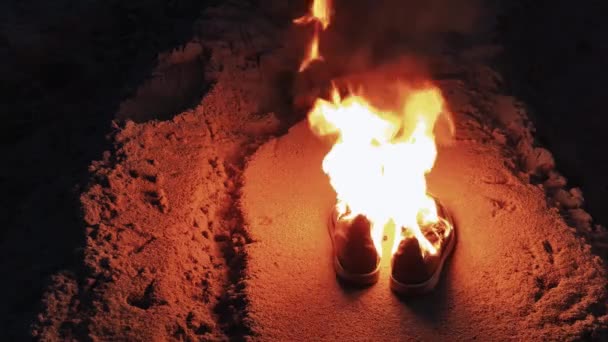 Brennende Stiefel im Sand an der Küste — Stockvideo