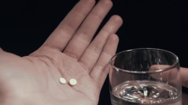 Tabletták és pohár víz a kezében elszigetelt fekete háttér ember figyelembe pirula Pov — Stock videók
