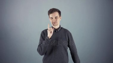 Boş bir poster gri arka plan üzerinde tutan genç adam