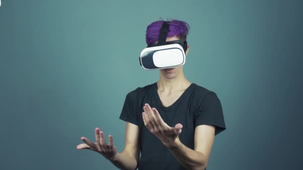 Jovem com franja roxa usando óculos vr headset fazendo gestos olhando ao redor — Vídeo de Stock