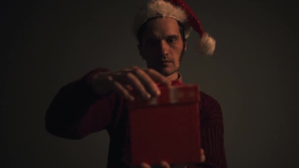 Крупным планом удивленного человека, открывающего светящуюся подарочную коробку в ночь на Рождество — стоковое видео