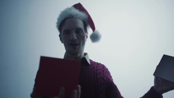 Kırmızı Santa Claus şapka openinng hediye kutusu ve gördüklerini ile mutlu genç adam