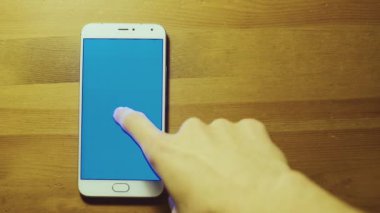 Erkek el dolar yığını üzerinde beyaz akıllı telefon srceen ahşap masa mavi tuş ile atar