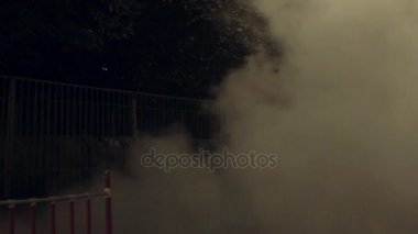 Gece şehir sokak, hızlı bir şekilde etrafında yayılmış Buhar bulut üzerinde kat duran kız