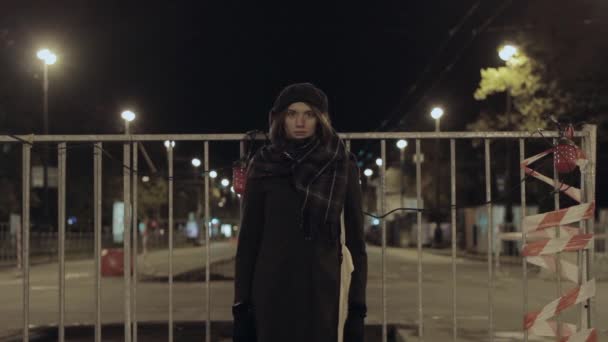 Mujer de pie frente a la carretera prohibido bloquear cercas, tráfico nocturno de la ciudad — Vídeos de Stock