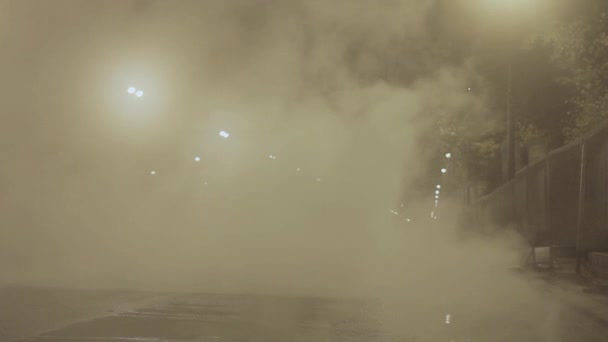 Homme marchant dans la rue nocturne de la ville couverte de vapeur blanche provenant d'un accident d'assainissement — Video